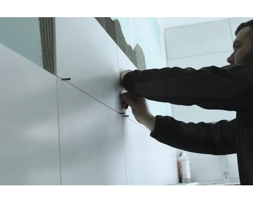 Carreleur au travail avec des carreaux et des cordons de carreaux