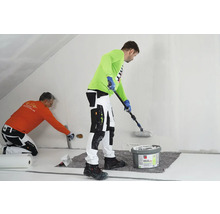 Zwei Handwerker tragen Rollspachtel auf eine Wand auf. Einer verwendet eine Rolle, der andere eine Spachtel.