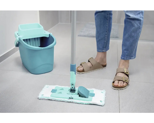 Scène de nettoyage avec une serpillère, un seau et une personne en sandales