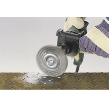 Brosse métallique en utilisation sur une surface métallique, manipulée par une personne portant des gants.