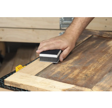 Bloc de ponçage utilisé sur une surface en bois.
