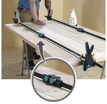 Porte en bois collée avec des serre-joints sur un établi.