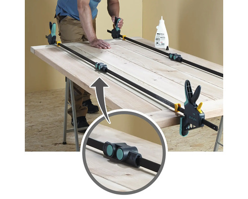 Porte en bois collée avec des serre-joints sur un établi.