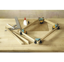 Établi avec serre-joints d''angle, tasseaux de bois, équerre, crayon et flacon de colle pour le travail du bois