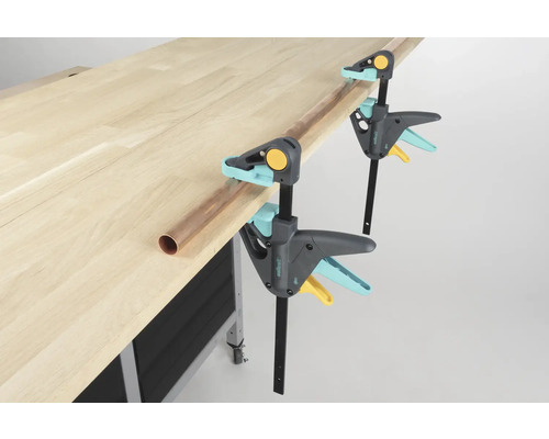 Établi avec deux serre-joints à une main Wolfcraft et un tube en cuivre.