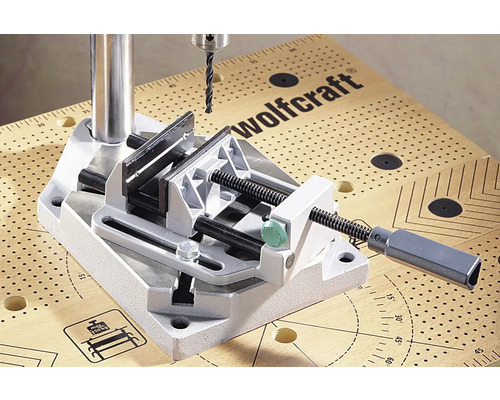 Wolfcraft Logo. Bohrständer mit Schraubstock auf einer Werkbank