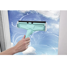 Nettoyeur de vitres en cours d'utilisation sur une surface en verre