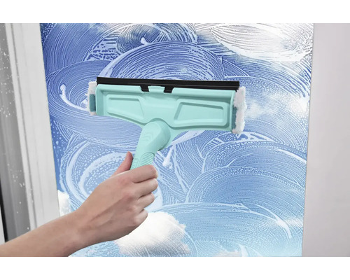 Nettoyeur de vitres en cours d'utilisation sur une surface en verre