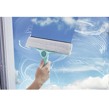 Nettoyeur de vitres avec housse de nettoyage et raclette en action sur une vitre