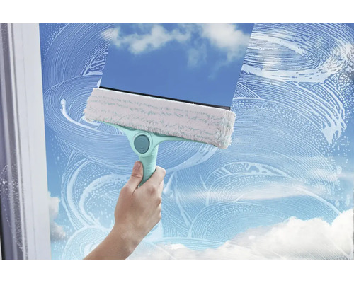 Nettoyeur de vitres avec housse de nettoyage et raclette en action sur une vitre