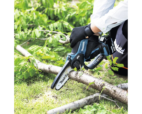Personne coupant une branche avec une tronçonneuse à batterie Makita