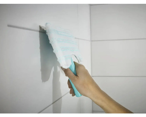 Une main essuie des carreaux avec un balai à franges plat