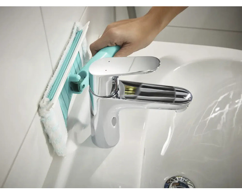 Nettoyage d''un mur de salle de bains avec un racloir de salle de bains à côté d''un lavabo.