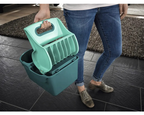 Person hält eine Katzenstreuschaufel und einen Behälter zum Reinigen von Katzenstreu.