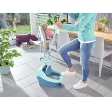 Femme utilise un balai à franges et un seau pour nettoyer le sol