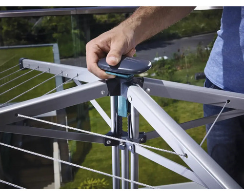 Drehflügelwäscheständer mit Person die den Mechanismus bedient