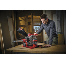 Mann bedient eine rote Einhell Kapp- und Gehrungssäge mit Werkstück