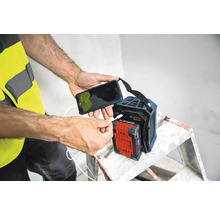Une personne recharge un téléphone portable sur une radio de chantier Bosch.