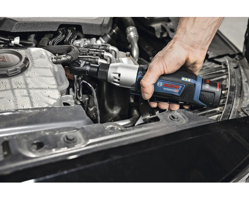 Une personne utilise une clé à chocs angulaire sans fil Bosch Professional sur le moteur d'une voiture.