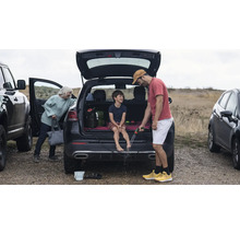 Scène avec une famille se nettoyant les pieds avec un tuyau d'arrosage après une excursion en plein air.