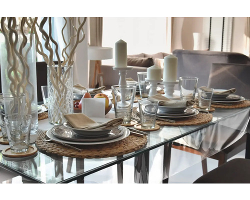 Table à manger dressée de manière festive avec vaisselle, verres, bougies et décoration