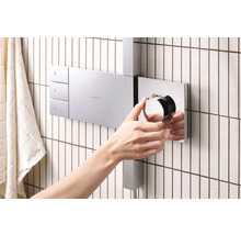 Person bedient Hansgrohe Duscharmatur im Badezimmer.