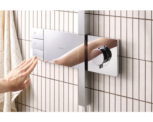 Elegante Duscharmatur mit Bedienelementen und Temperaturregler an einer gefliesten Wand