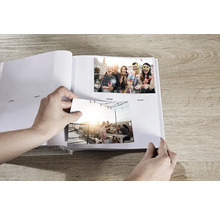 Personne collant des photos dans un album photo.