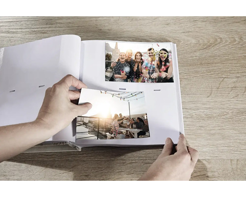 Personne collant des photos dans un album photo.