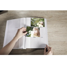Album photo ouvert avec une personne insérant des photos