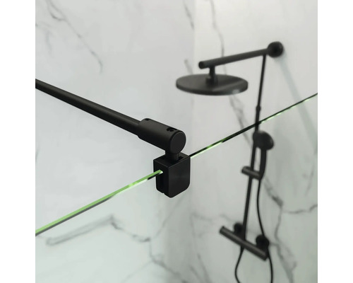 Gros plan d'une cabine de douche avec barre de stabilisation noire et robinetterie de douche