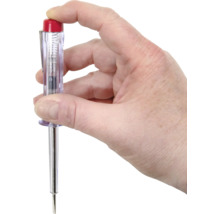 Une main tient un testeur de tension.