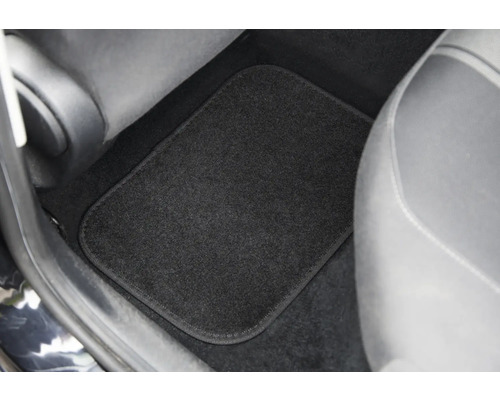 Schwarze Fußmatte im Fußraum eines Autos.