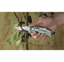 Couteau pliant Stanley coupant une branche