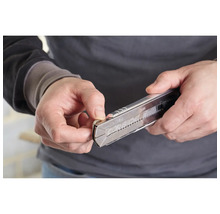 Eine Person bedient ein Cuttermesser.