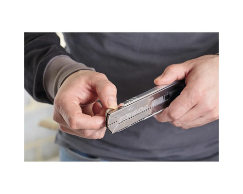 Eine Person bedient ein Cuttermesser.