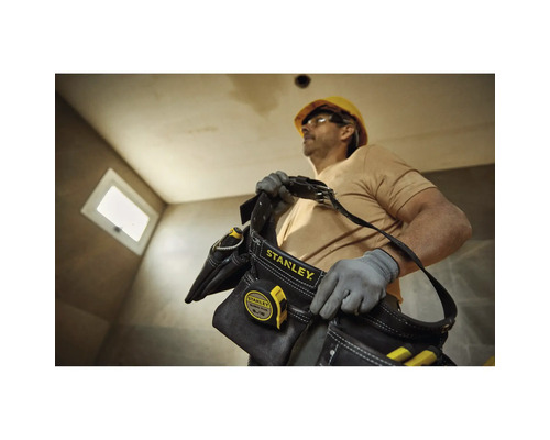 Artisan avec sac à outils Stanley et mètre ruban sur un chantier