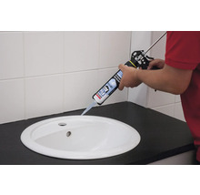 Application de la colle cristal Soudal Fix All avec un pistolet à cartouche sur un lavabo