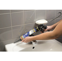 Application de silicone sanitaire avec un pistolet à cartouche dans la salle de bain