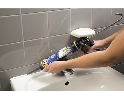 Application de silicone sanitaire avec un pistolet à cartouche sur un lavabo