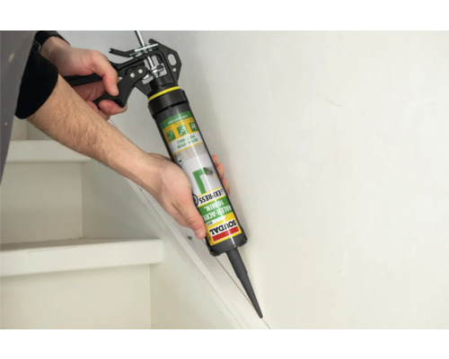 Eine Person verwendet eine Kartuschenpistole zur Anwendung von Soudal Acryl Dichtstoff auf einer Treppe.