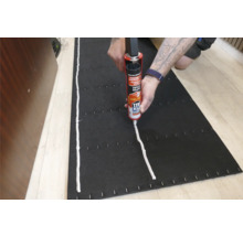 Application d'adhésif de montage sur un panneau isolant noir avec un applicateur