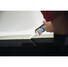 Une main scelle un lavabo avec du Soudal Fix All Flexi