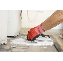 Carreleur appliquant de la colle sur des carreaux