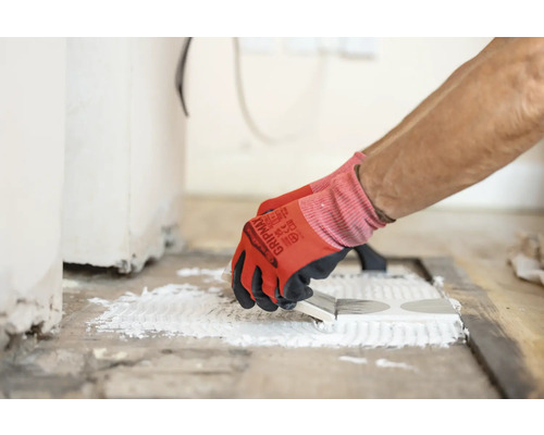 Carreleur appliquant de la colle sur des carreaux