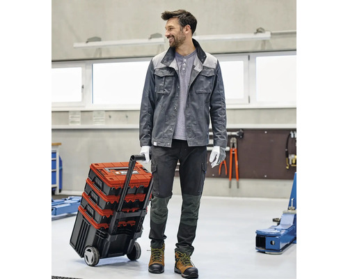 Artisan avec une caisse à outils à roulettes dans un atelier
