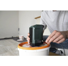 Mann schliesst Lautsprecher an Stromquelle an