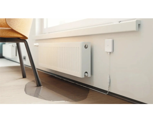 Radiateur sous une fenêtre avec un capteur de température connecté