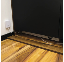 Vue détaillée d'un meuble bas avec prise et câble sur un plancher en bois