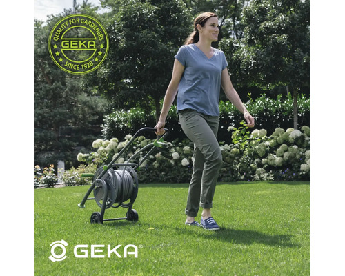 Frau zieht einen Schlauchwagen durch den Garten